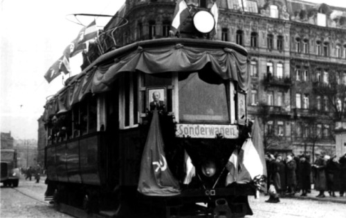 Anonymous. The Austrian flag flutters alongside the hammer-and-sickle on a tram crossing a newly rep