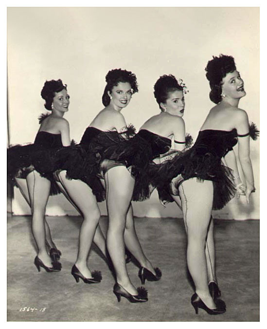 Vintage 50’s-era photograph features a quartet of showgirls posing Backstage, at