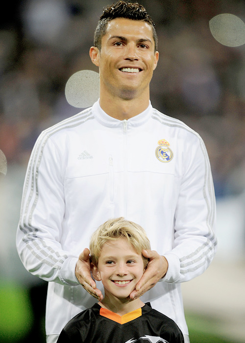 madridistaforever:  Cristiano Ronaldo jokes with a player escort during the UEFA Champions League Group A match between Real Madrid and Paris Saint-Germain | November 3, 2015