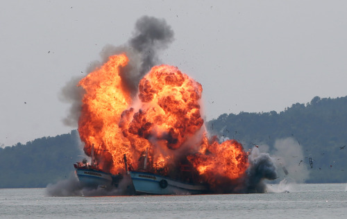 A fireball goes up as foreign fishing boats are destroyed by the Indonesian Navy off Batam Island, I