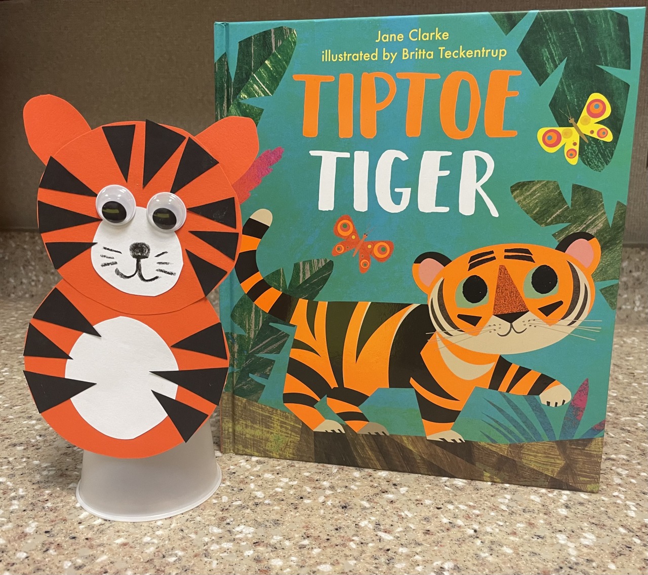 The book shows an illustrated tiger walking through the jungle. It's pictured next to a completed craft, as described below