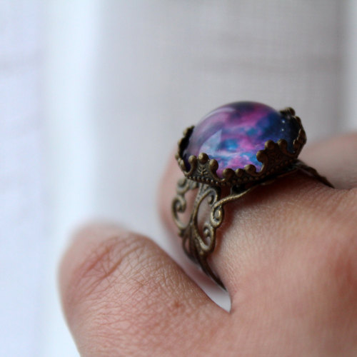 wickedclothes:  Adjustable Violet Nebula Ring A glass dome rests on this fully adjustable, antique brass ring. Inside of the dome is a vibrant picture of a violet-colored nebula. An accessory that your friends will surely say is “out of this world.”