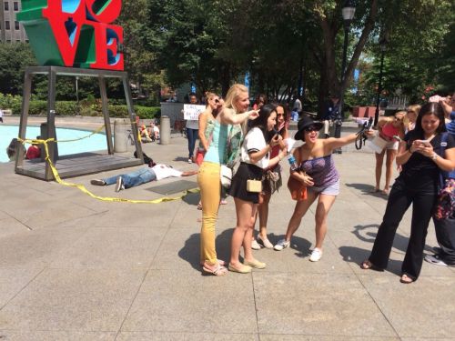 thatblackveganguy:  ras-al-ghul-is-dead:  A silent protest in Love Park, downtown Philadelphia orchestrated by performance artists protesting the murder of Michael Brown in Ferguson. The onslaught of passerby’s  wanting to take photos with the statue