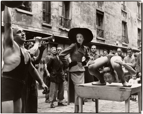 Elise Daniels with street performers, suit by Balenciaga, Le Marais, Paris, August 1948, Fashion Por