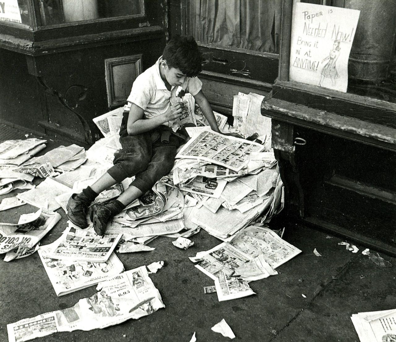 bewarethebibliophilia:  A kid reading comics at a paper recycling site, NYC, October