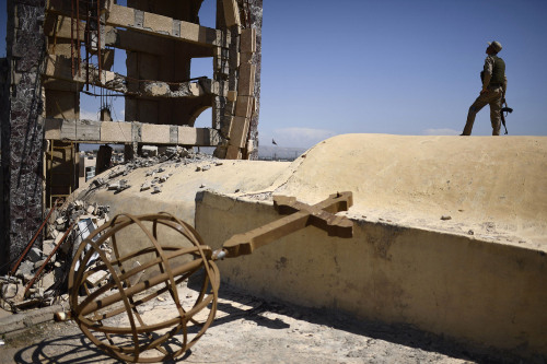 A Syriac Christian militiaman stands guard on top of the St. John&rsquo;s church (Mar Yohanna) durin