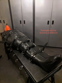 feelingknottycda:On a cold November night, EpixBound kindly offered to help me warm up by putting me into my leather sleepsack. The night started out with him hooding me and putting on headphones playing white noise. Into the sack I went, with the straps