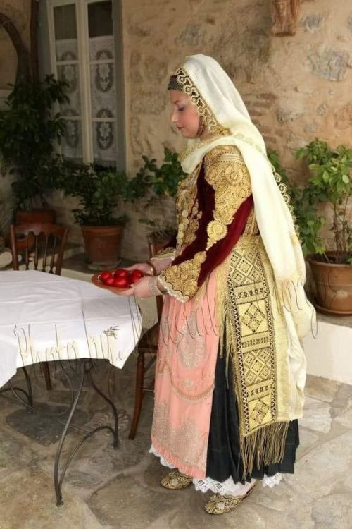 Traditional clothing from Megara, Macedonia, Greece. The woman carries red eggs for Easter