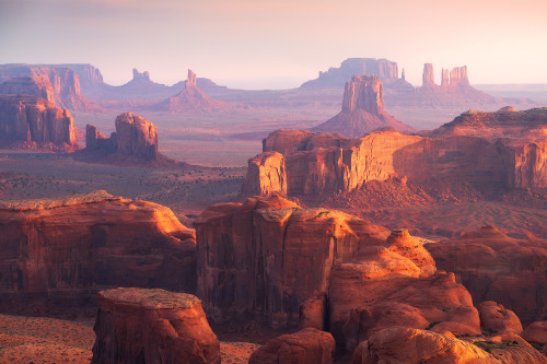 amazinglybeautifulphotography:First light on the sandstone pillars of Monument Valley [OC] [2000x133