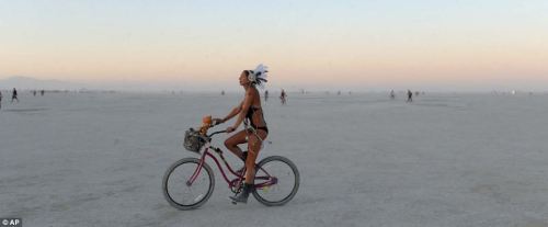 vandergraff:   A woman rides a bicycle at Burning Man after sunset in Nevada’s Black Rock Desert