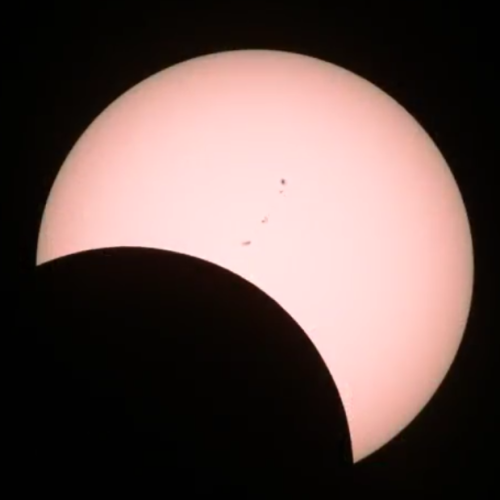 alanturng:solar eclipse moving toward totality, with a pink filter, captured from the natgeo livestr