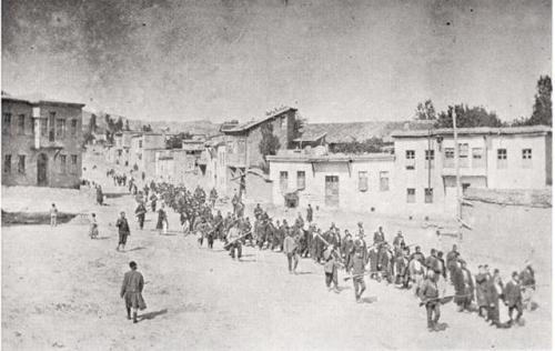 Armenian civilians, escorted by Ottoman soldiers, are escortedthrough Kharput to a prison in nearby 
