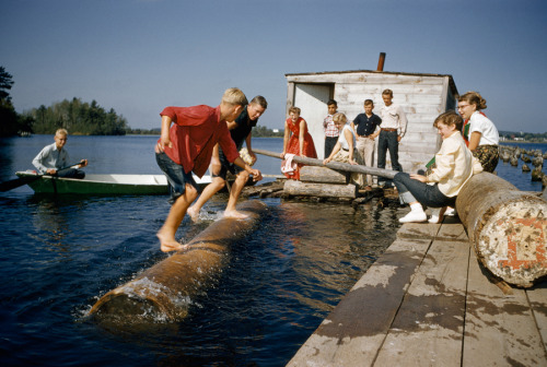 Sons of lumberjacks try to upset one another on rolling log in Hayward, Wisconsin, Feburary 1957.Pho