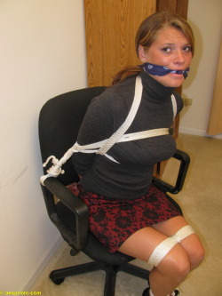 graybandanna:  Tied to her office chair with a blue bandanna knotted cleave gag