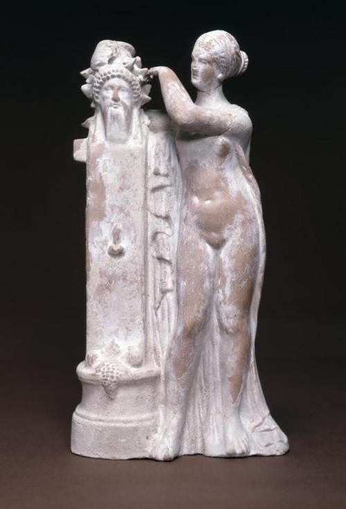 mythologyofthepoetandthemuse: Terracotta figure of Aphrodite crowning a herm of Dionysus with an ivy