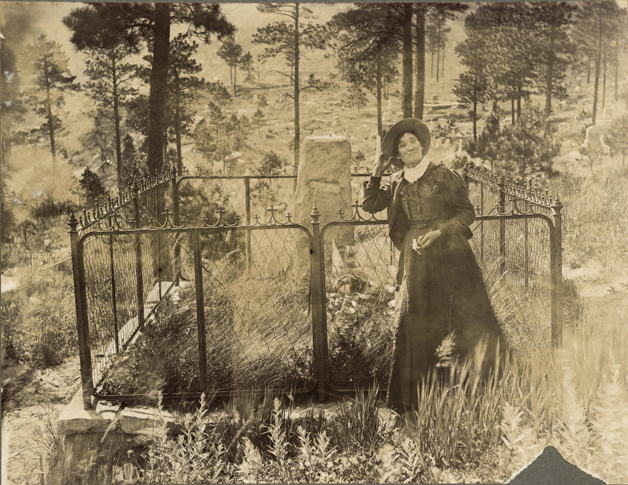 onceuponatown: Calamity Jane at the grave of Wild Bill Hickok, Deadwood, South Dakota,