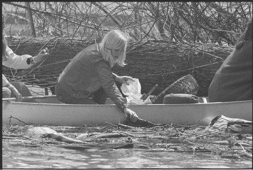 A Girl Scout in a canoe, picking trash out of the Potomac River during the first-ever Earth Week in 