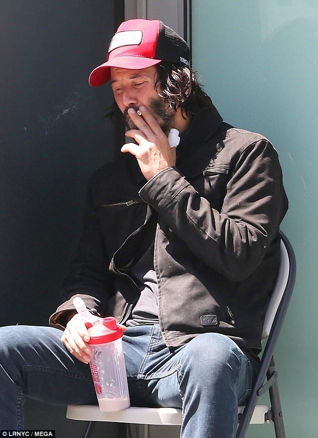 keanuital:    Keanu Reeves sports an injured thumb as he takes a smoke break on the