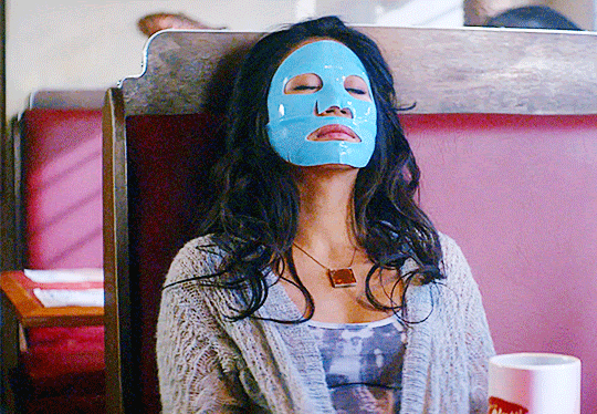 GIF FROM EPISODE 1X07 OF NANCY DREW. VICTORIA SITS IN A BOOTH AT THE CLAW WITH HER HEAD RESTING AGAINST THE BACK OF THE BOOTH. SHE HAS AN AZURE BLUE FACE MASK COVERING HER FACE WITH OPENINGS FOR HER EYES, NOSTRILS, AND MOUTH. HER EYES ARE CLOSED.
