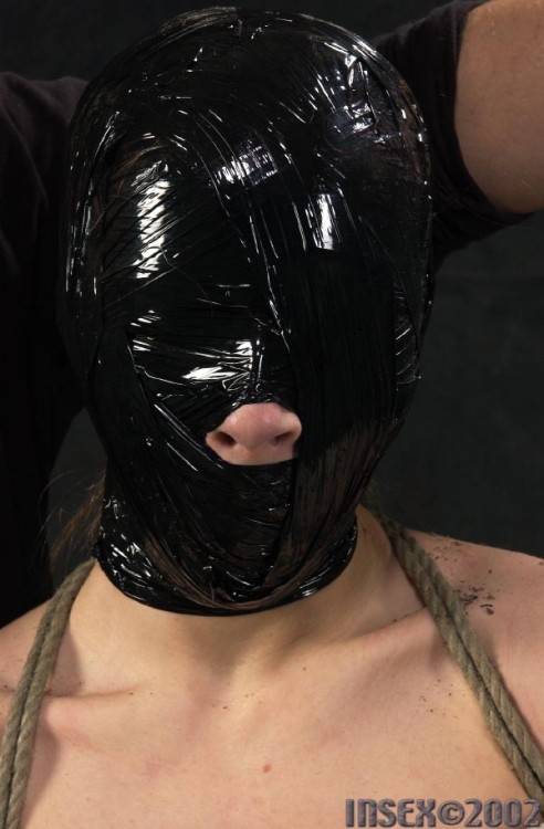 putmeinherplace:  I find layered bondage quite fascinating. Here, we have a mummy wrap, over which a leather muzzle is applied, followed by a loose leather hood and a burlap sack, and a large cloth bag for the final suspension. Quite a treat.