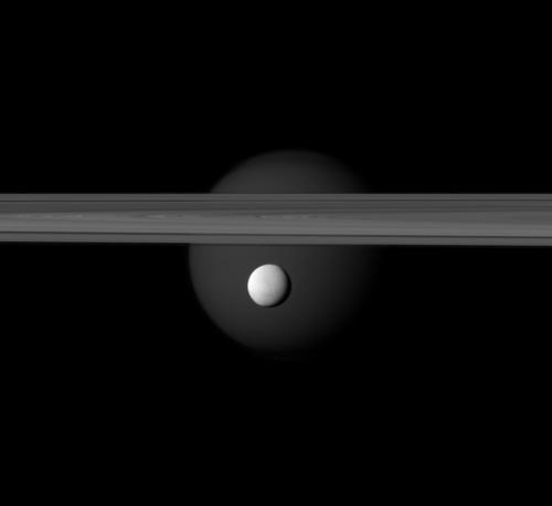 Enceladus in the foreground, Saturn’s rings and Titan in the background.