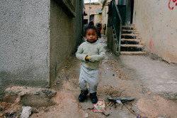 4npictures:  A girl walking with food in her hands through the muddy streets of Gaza Palestinian refugee camp in Jordan January 20, 2016. 