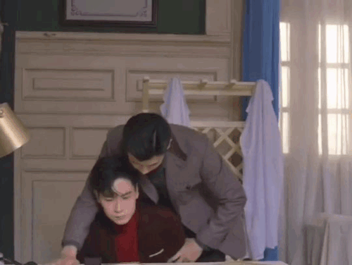 chusheng hovering over lu yao while reading something from a document on the desk in front of lu yao