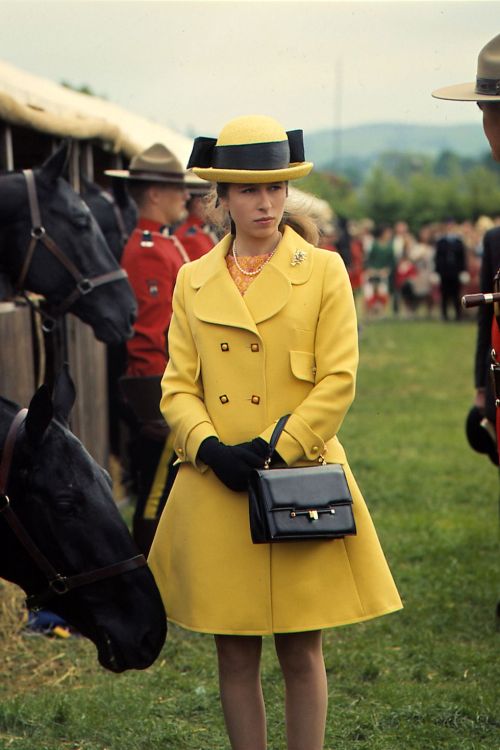 1968Princess Anne wears a yellow coat and hat at the Horse Trials with members of the Royal Canadian