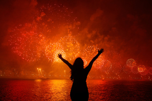 cameralens:  Pilar Oliviares/Reuters A woman celebrates the new year as she watches fireworks exploding above Copacabana beach in Rio de Jeneiro on Jan 1. More than two million people gathered along Rio’s most famous beach to witness the 20-minute display