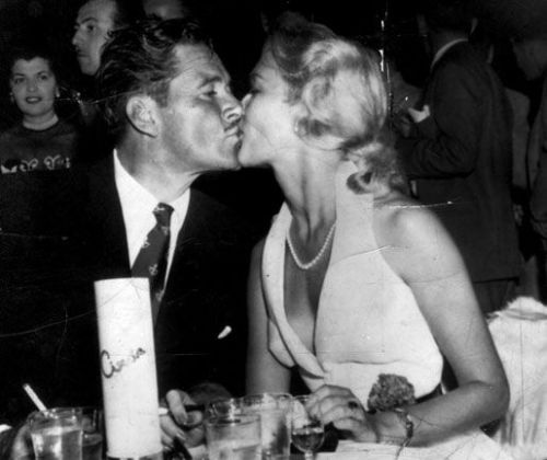 the-marriage-of-heaven-and-hell:Errol Flynn kisses his wife Patrice Wymore at Ciro’s, Hollywood, 195