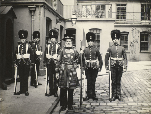 The Executioner of the Tower, standing in front of five Guardsmen on Tower Green within the Tower of