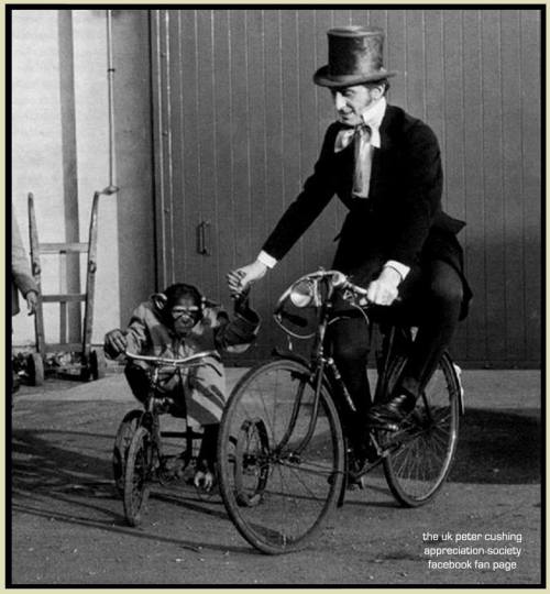 petercushingappreciationsociety:Peter Cushing on a bike with a partner and co star on a tricycle. Th
