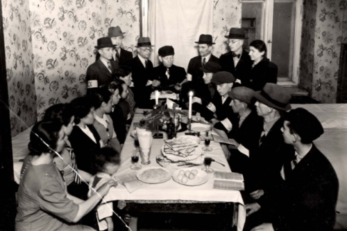 A Passover Seder in the Warsaw Ghetto, PolandJews around a Seder table reading from the Passover Hag