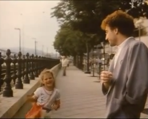 John Deacon talks to a young girl in Budapest, Hungary (1986)Girl: [says something unintelligible]De