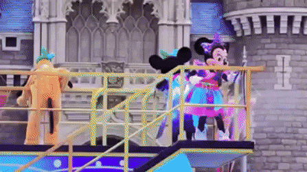 A gif from a Disneyland performance where Minney's mascot fires a flamethrower to the right from the top of the float, causing an explosion.