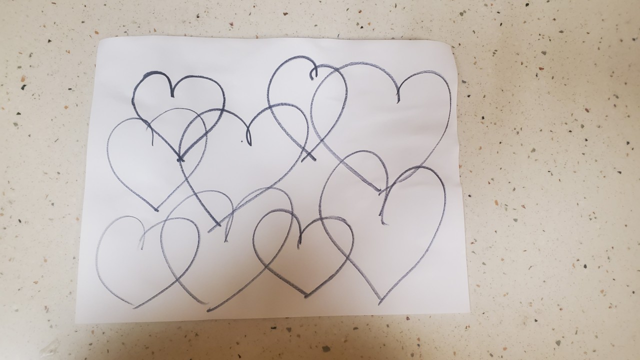 Paper with several hearts drawn in black marker overlapping