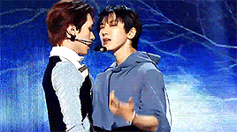 A continuation of the gif from their MusicCore performance. They lean in closer before looking at the camera and smile when they notice their mics are tangled.