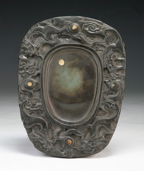  A Chinese Antique Duan Ink Stone: of rounded rectangular form, well carved with motifs of drag