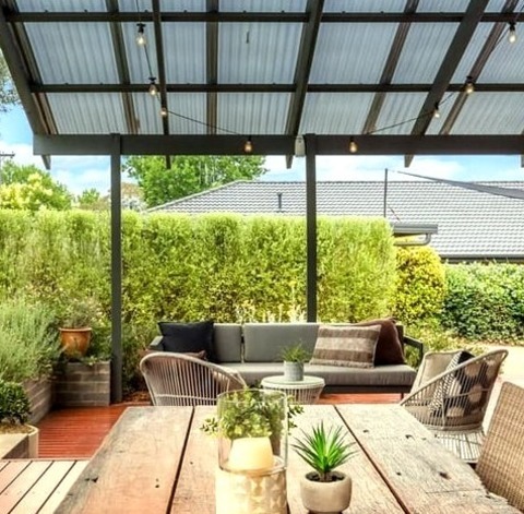 An Illustration Of A Sizable, Minimalist Backyard Deck With A Pergola