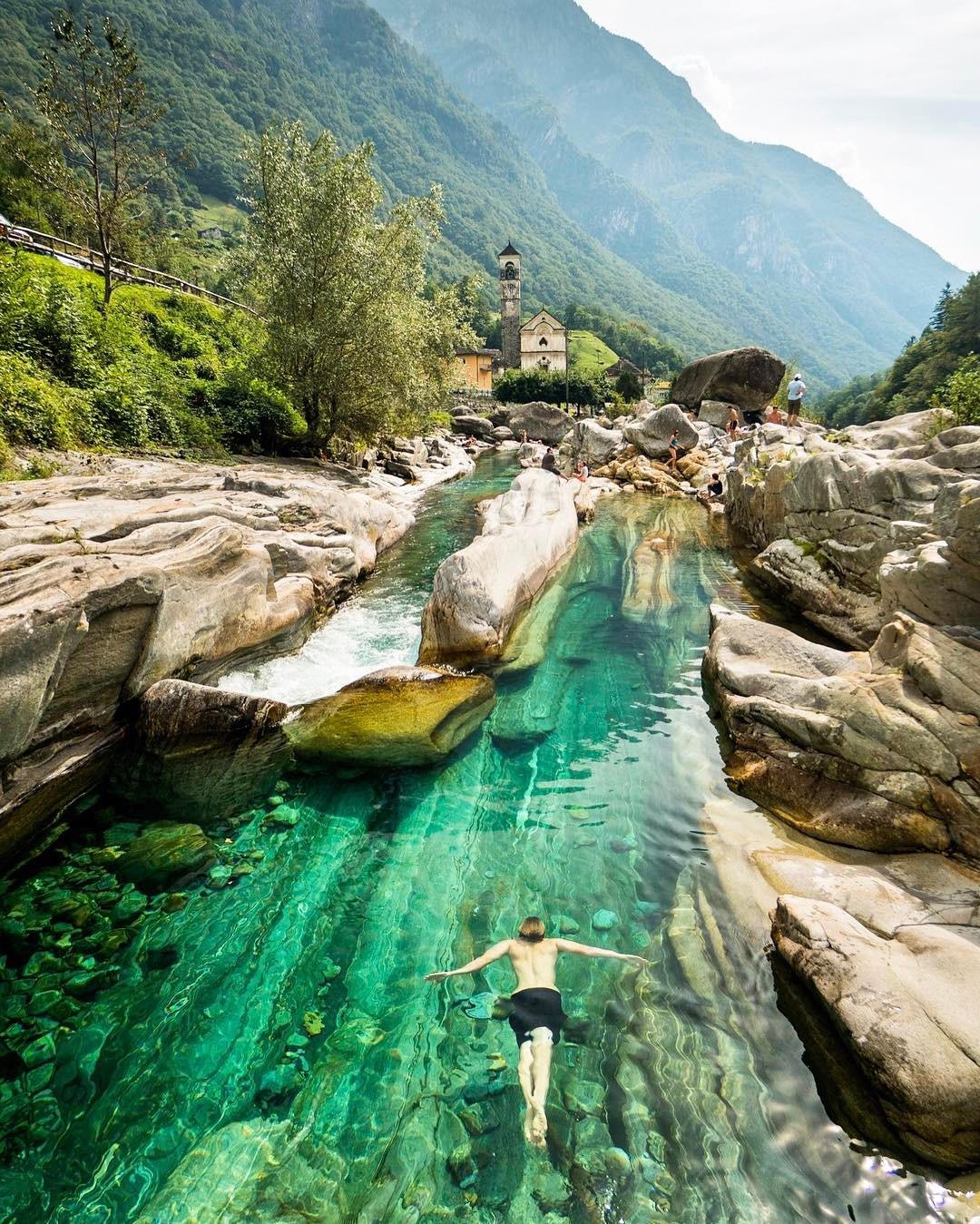 sixpenceee:Swimming in the crystal green waters, Lavertezzo, Switzerland. Via reddit