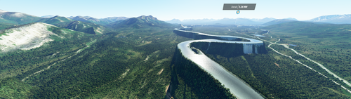 A panoramic view of a wide mountain landscape in Alaska’s Denali National Park. A river winds through the valley, on its own steep-sided platform elevated thousands of feet high.