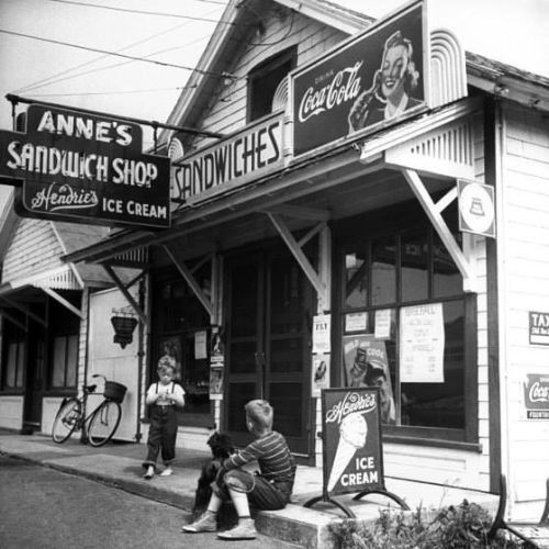 Two young boys and their dog outside Anne’s sandwich shop on a summer day on Cape Cod, 1946. (