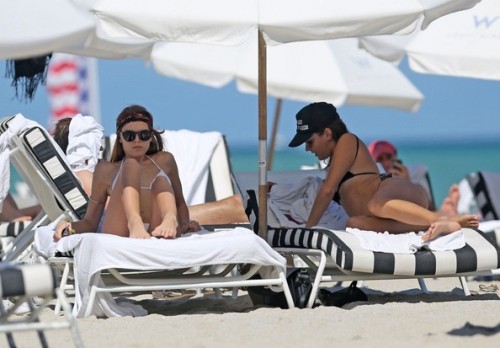 Maryna Linchuk wears a white bikini as she and a friend spend the day at the beach.