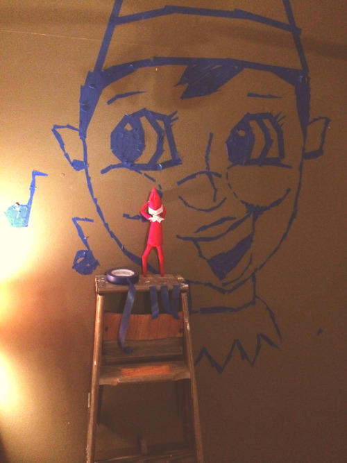 Elf on the Shelf Mural The elf wanted to give everyone a reminder for when he goes back to the North Pole, so he created a giant mural of his face out of blue painters tape!
