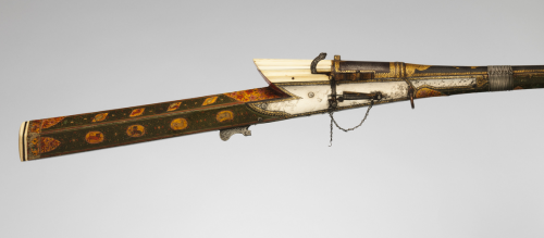 An ornate matchlock musket, lacquered and decorated with gold, silver, copper, and ivory.  Originate