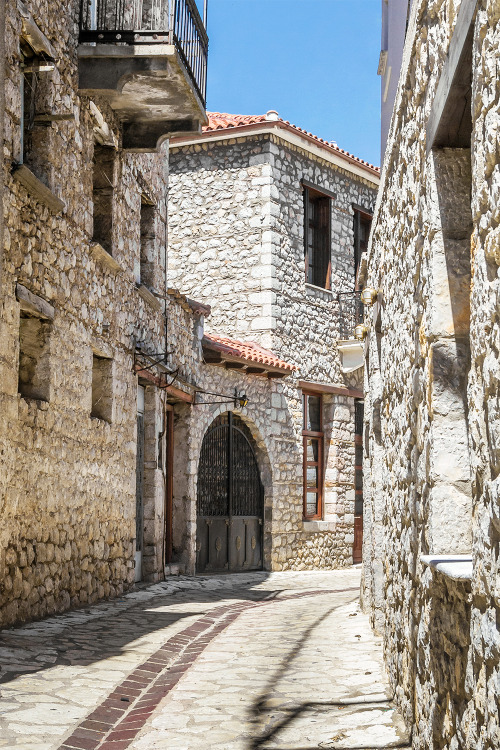 Sunny cobblestone street and houses, Arachova (Boeotia, Greece)