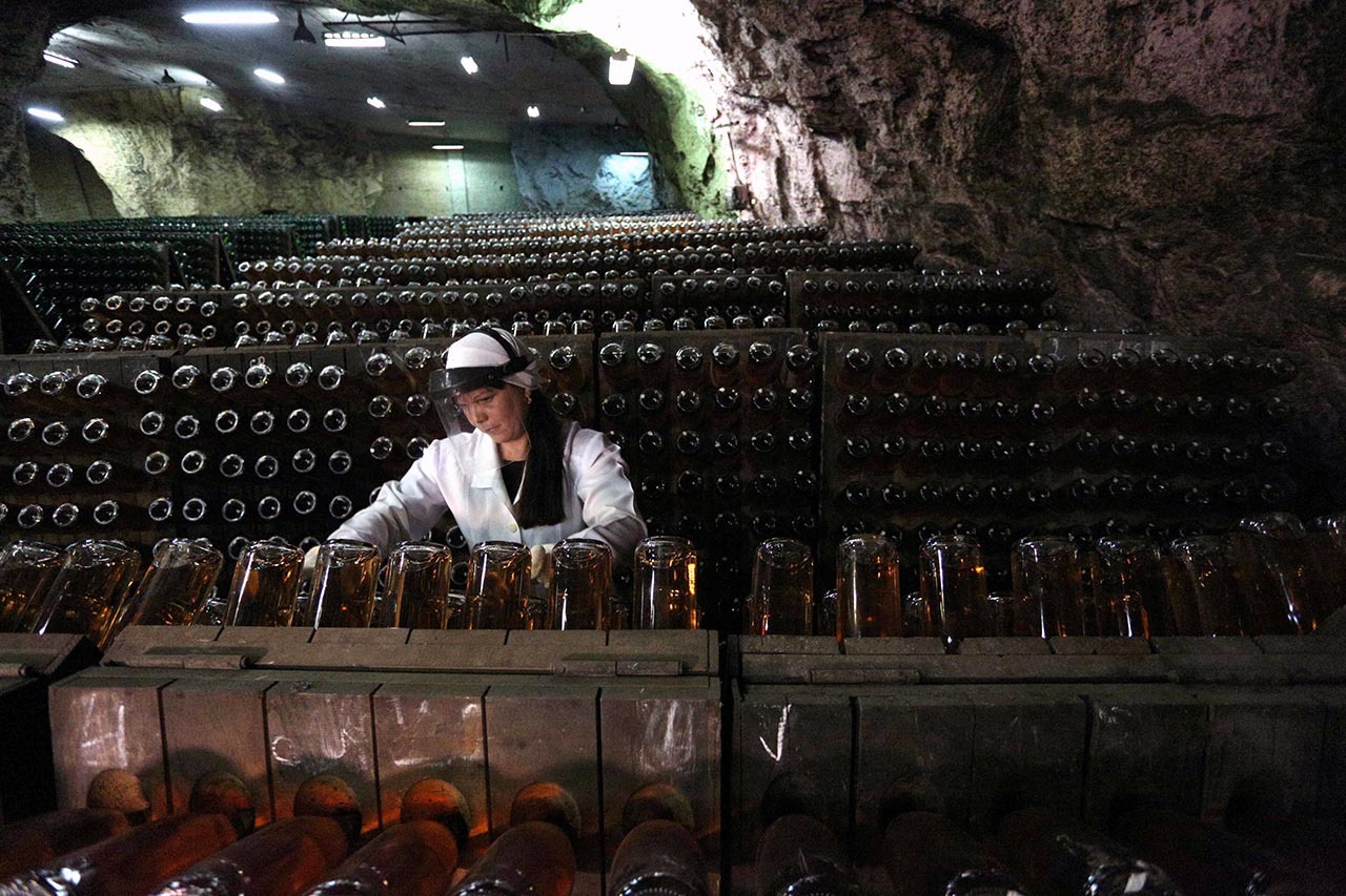 CAVA PROFUNDA. En el fondo de una enorme y antigua mina, a tan sólo unos kilómetros de la línea del frente, cientos de miles de botellas de vino espumoso aguardan en un laberinto de túneles y bodegas, en Ucrania. Es un refugio antibombas de 25...