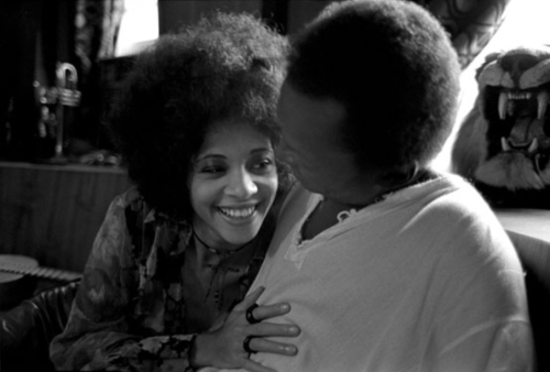 twixnmix:Miles Davis and his wife, funk singer, Betty Davis in front of one of his paintings at thei