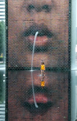 xauji:  jewist:  This is Crown Fountain in Millennium Park in Chicago. It is a 50-foot glass block tower that projects the faces of some chicagoans. Water gushes from their mouths into a shallow reflecting pool.  I love that park