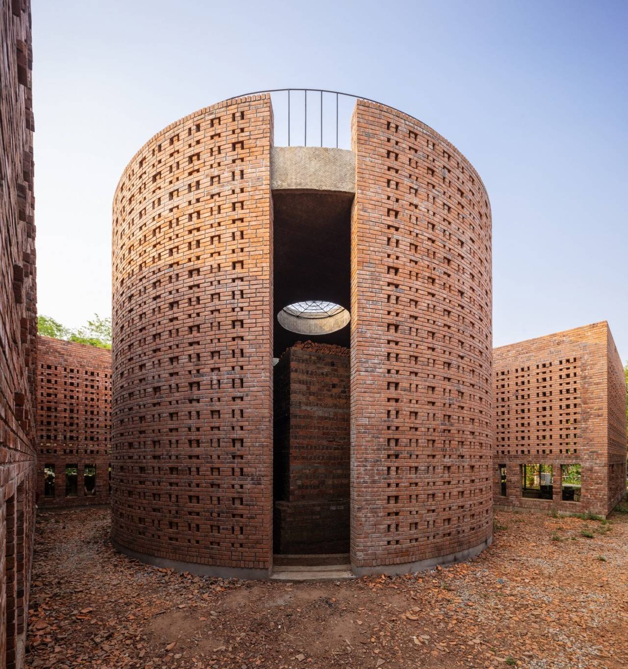 a cylindrical brick structure in a courtyard surrounding an old kiln